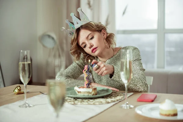 Birthday woman lightning the candle on birthday cake staying alone — Stock Photo, Image
