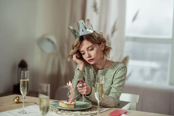 Birthday woman using lighter burning the candle on piece of cake — Stock Photo, Image