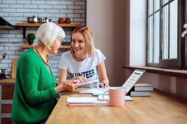 Vadesi geçmiş kredi raporları ile sosyal bölümü alt yardım gri saçlı kadın.