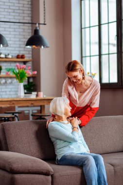 Güzel genç-yetişkin Bayan usulca anne omzuna elini koyarak