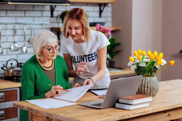 Voluntariado tratando de persuadir a la anciana a firmar un préstamo vencido — Foto de Stock