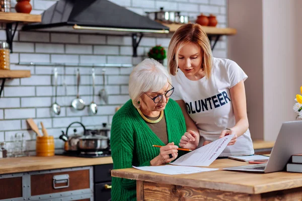 Hechicera voluntaria explicando envejecimiento mujer atrasado préstamo solicitud puntos principales — Foto de Stock