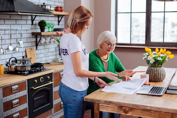 Mujer joven aclarando artículos madam ancianos de notificación de préstamo atrasado — Foto de Stock