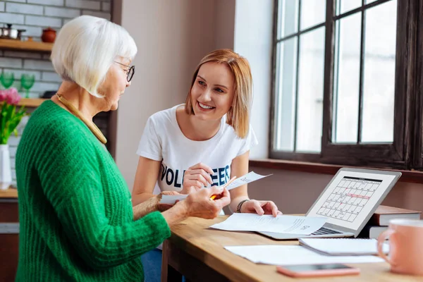 Pensionerad dame tittar på lån betalningsdatum på laptop kalender — Stockfoto