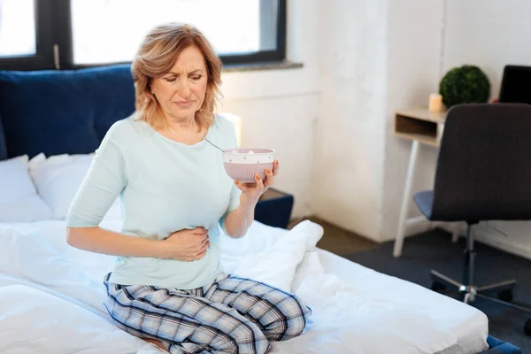 Good-looking confused woman having problem with her stomach — Stock Photo, Image
