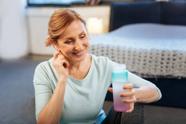 Angenehme ältere Dame mit gebundenen Haaren, die ihr Kinn berühren — Stockfoto