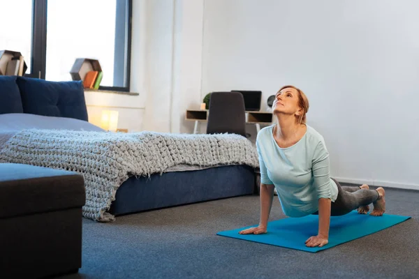 Resolute sportive thin lady standing on her hands while training