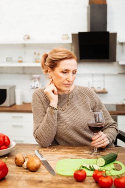 Sebze ile hafif yemek hazırlama düşünceli ışık saçlı kadın