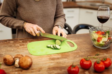 Doğru iyi görünümlü Bayan bej kazaklı salatalık doğrama