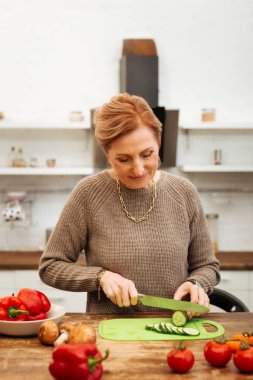 Evde yalnız olmak ve yemek hazırlama süveterin içinde yakışıklı gülen