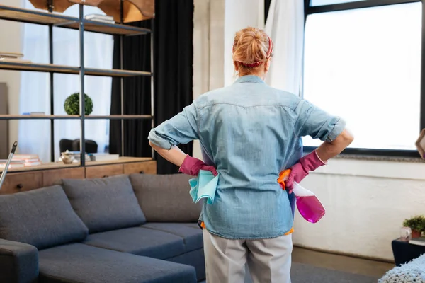 Mujer decidida con el pelo atado observando su apartamento y la planificación — Foto de Stock