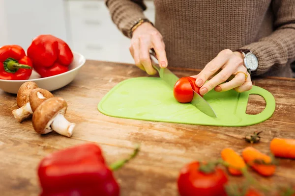 Neat woman in warm sweater getting her dinner ready while chopping — Stock Photo, Image