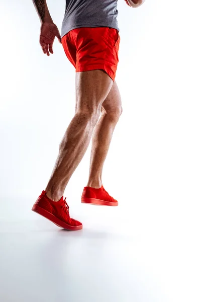 Figura masculina con pantalones cortos rojos realizando movimientos de carrera — Foto de Stock