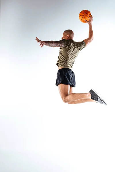 Man jumping high with a basketball ball in his hand — Stock Photo, Image