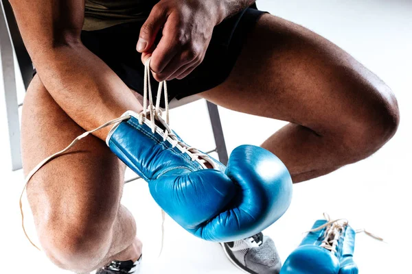 Człowiek, sznurowanie niebieskie rękawice bokserskie na szkolenie — Zdjęcie stockowe