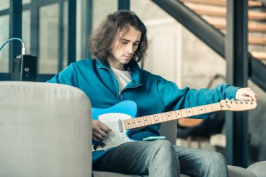 Müzik aleti kurma dalgalı saç ile genç gitarist odaklı