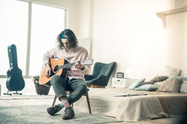 Esmer odaklı çapraz ayaklı oturan ışık gömlekli adam