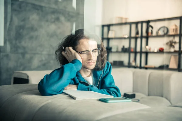 Confundido músico joven de cabello oscuro que se queda atascado durante el proceso de creación — Foto de Stock