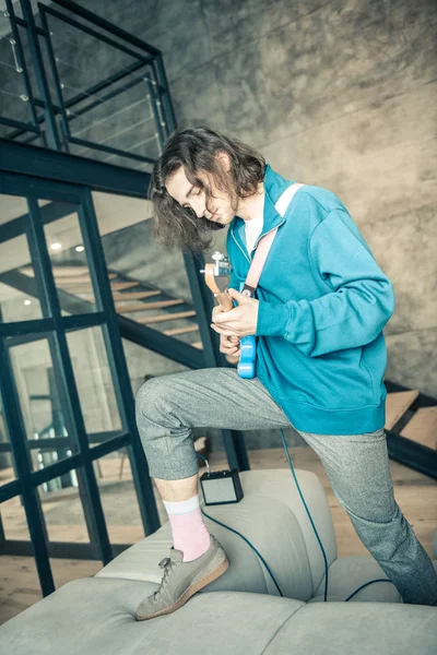 Actieve dark-haired beroepsmuzikant in blauwe trui en korte broek — Stockfoto