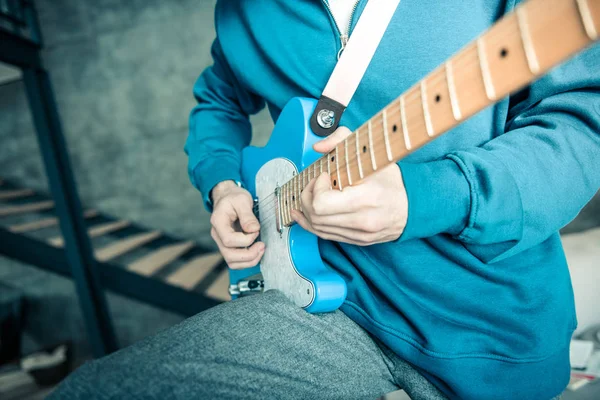Músico profesional en sudadera brillante llevando la guitarra electrónica azul — Foto de Stock