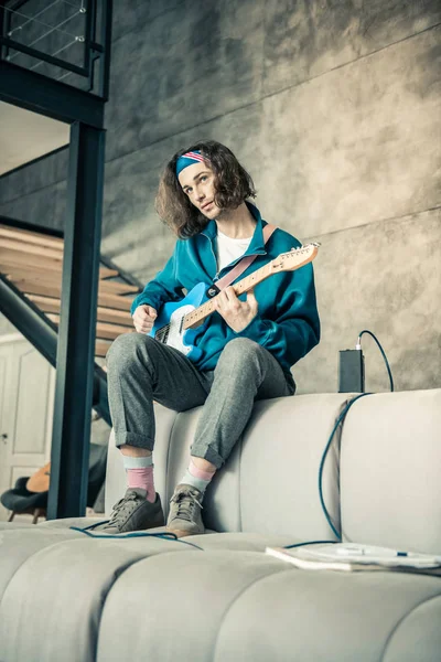 Curioso músico joven y apuesto aprendiendo nuevos acuerdos y técnicas — Foto de Stock
