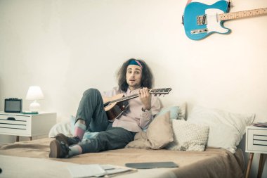 Yastık ile çevrili yatakta oturmuş ifade yakışıklı