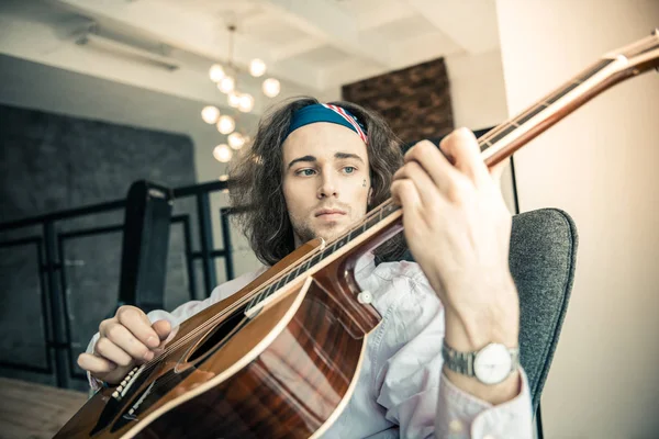 Sad good-looking guy wearing colorful bandana and having tattoo on the face — Stock Photo, Image