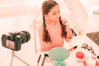 Güzel genç kız üfleme üzerinde bu makyaj fırça