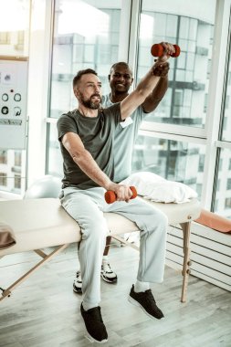 Memnun sakallı adam rehabilitasyon fiziksel egzersizleri yapıyor