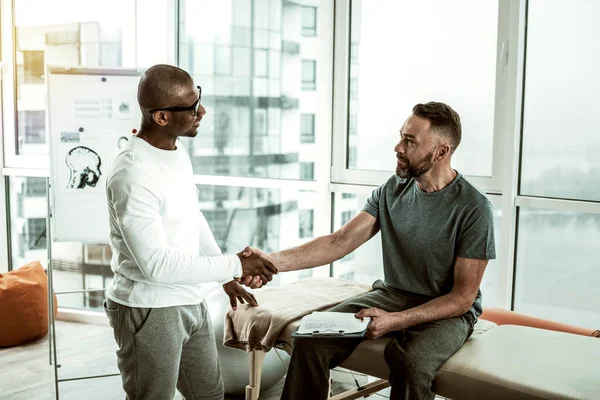 Glad manlig person skakar hand med sin läkare — Stockfoto