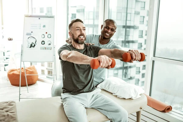 Vrolijke baard man doet oefeningen met plezier — Stockfoto