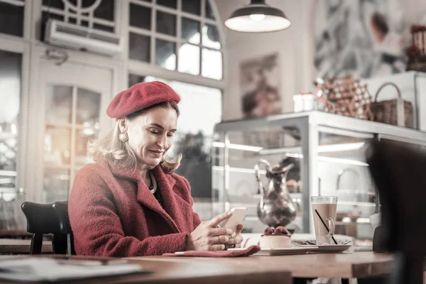 Vriendelijke blonde rijpe vrouw draagt de rode baret — Stockfoto