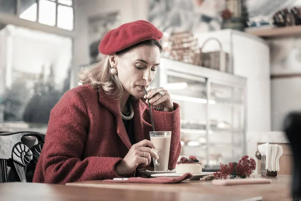 Konzentrierte reife Frau trinkt heiße Schokolade im Café — Stockfoto