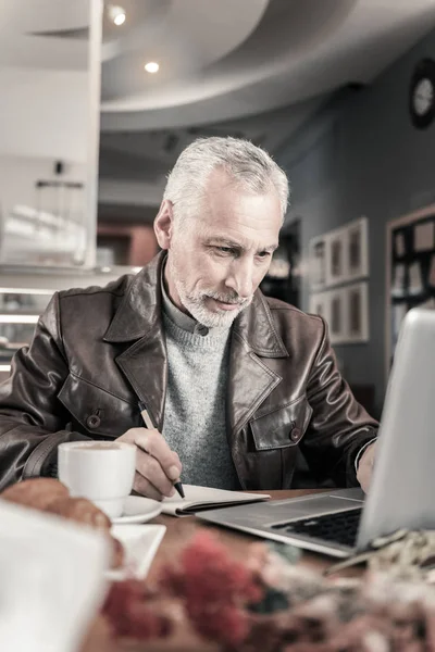 Freudiger reifer Mann, der am Computer auf Distanz arbeitet — Stockfoto