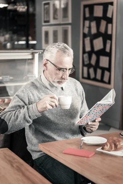 Συμπυκνωμένο γενειοφόρος άνδρας, διαβάζοντας ποιήματα σε καφετέρια — Φωτογραφία Αρχείου