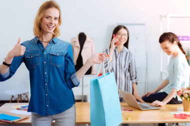Attractive blonde woman holding blue paper-bag