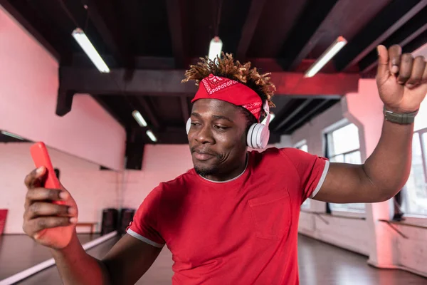 Activo joven contento en camiseta roja con música de baile —  Fotos de Stock