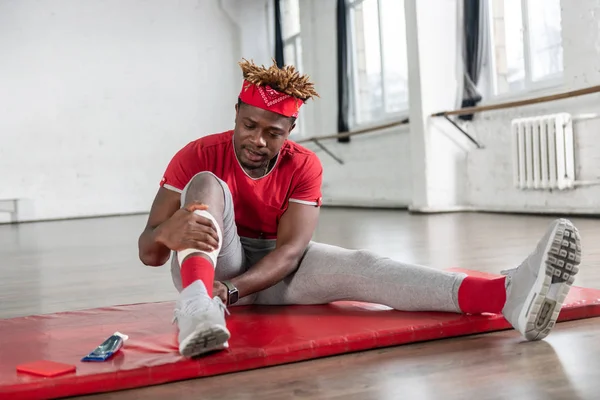 Appealing fit man being concerned with trauma in gym