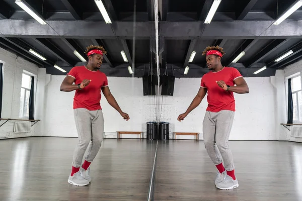 Hombre en forma activa en traje deportivo bailando delante del espejo —  Fotos de Stock