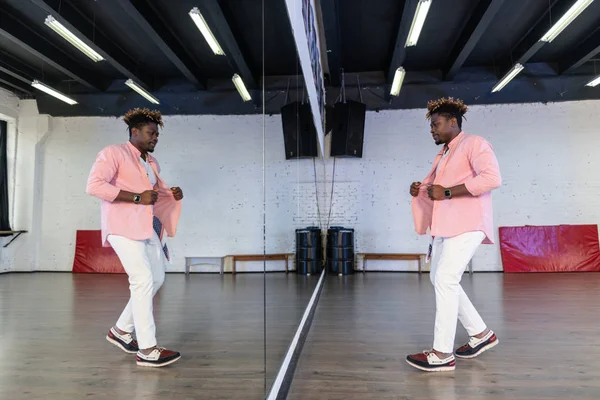 Hombre flexible inspirado en camisa rosa de pie frente al espejo de cuerpo entero — Foto de Stock