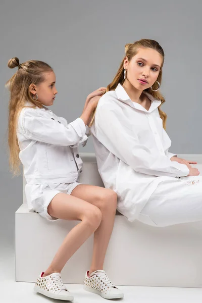 Niño atento en chaqueta blanca que se concentra en peinar el cabello —  Fotos de Stock