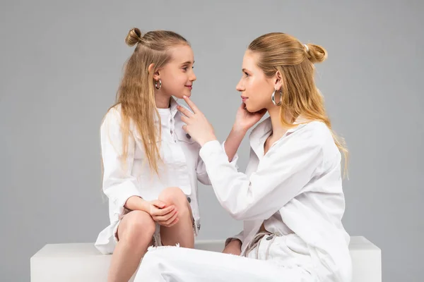 Hermanas guapas de pelo largo en trajes blancos que se tocan suavemente — Foto de Stock