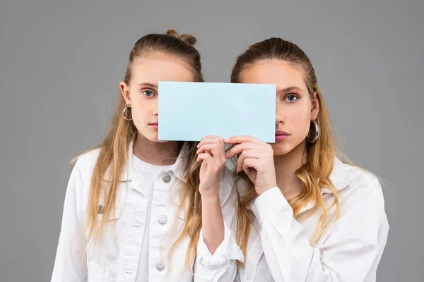 Appealing good-looking similar girls in white outfits carrying clear nameplate — Stock Photo, Image