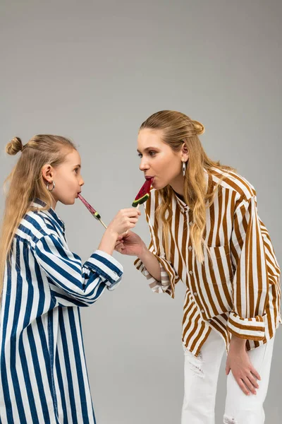 Nieuwsgierige goed uitziende dames in funky shirts proeverij elke andere snoepjes — Stockfoto