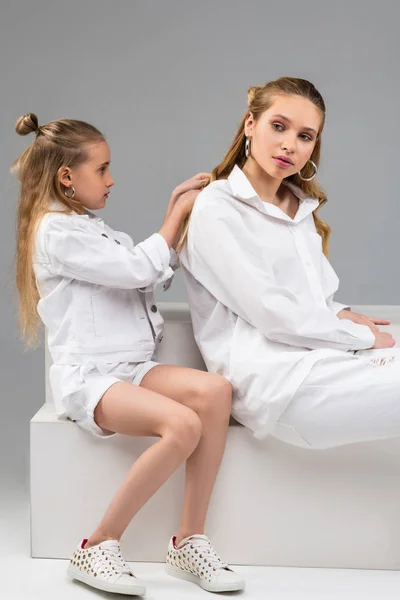 Attentive young kid in white jacket being concentrated on styling hair — Stock Image Attentive young kid in white jacket being concentrated on styling hair Royalty Free Stock Images