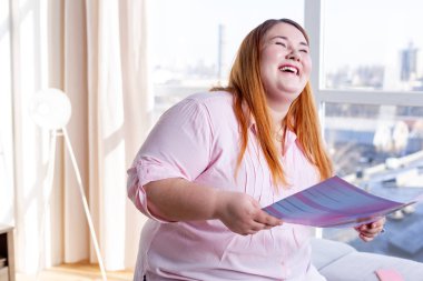 Elinde bir dergi tutan neşeli mutlu kadın