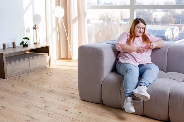 Agradable mujer regordeta mirando la pantalla de su teléfono —  Fotos de Stock