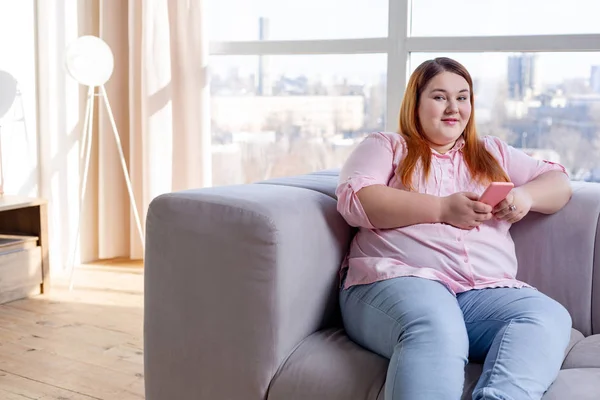 Schöne mollige Frau hält ihr Smartphone in der Hand — Stockfoto