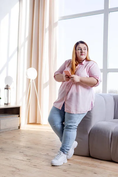 Mulher gorda bonita de pé na sala de estar — Fotografia de Stock