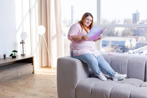 Angenehme nette Frau beim Lesen einer Schönheitszeitschrift — Stockfoto